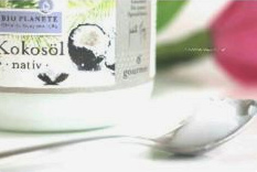 Virgin coconut oil in a glass and on
                        the spoon