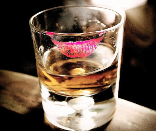 Ein mit Lippenstift
                verschmutztes Glas [6] - die Frau trinkt den Lippenstift
                mit der Oberlippe