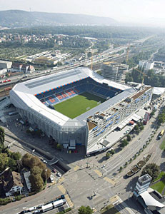 Fussballstadion mit Einkaufszentrum und
                            Parkhaus (Beispiel Basel)