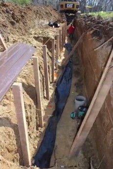 Der Graben bekommt einen Schlauch zur
                              Entw�sserung und Bel�ftung, und einige
                              Pfosten sind schon eingeschlagen 2