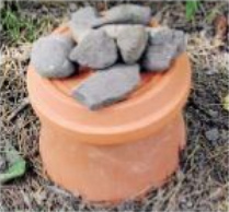 Ein Topfuntersatz wird kopf�ber auf den
                    Steinring gelegt und mit grossen Steinen markiert