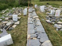 Construction of a
                            free-standing dry stone wall with cords
                            marking the inclination
