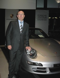 Ego-Verirrung Auto-Sucht: Weisser Mann in
                          Sacco und Kravatte mit Porsche