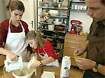 Eltern mit Tochter backen einen Kuchen