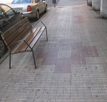 Trottoir / Bürgersteig in gerillten
Platten mit gelb-rotem Muster Trottoir /
Bürgersteig in gerillten Platten mit gelb-rotem
Muster