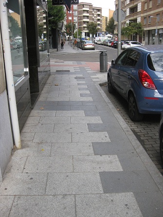 Trottoir / Bürgersteig in weissen Platten
mit schwarzen Bändern und Zahnradband Trottoir / Bürgersteig in weissen Platten
mit schwarzen Bändern und Zahnradband