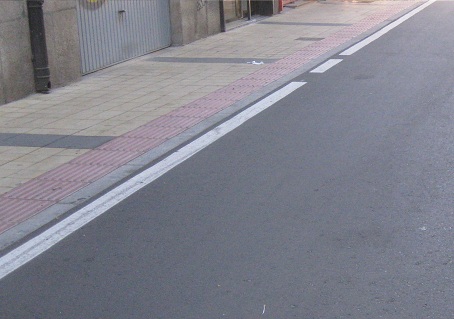 Trottoir in gelben Platten mit rotem Band
am Rand und schwarzen Querbändern Trottoir
in gelben Platten mit rotem Band am Rand und
schwarzen Querbändern