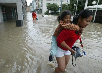 Sarnen
                          (Switzerland): tourist in the floods with a
                          child on her back (August 2005)