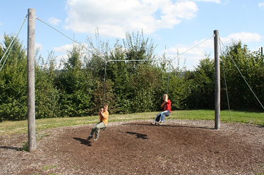 Plate swing ensemble with two boys on
                              a woodchip ground (with sawdust),
                              Dietingen, BW, Germany