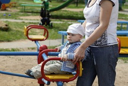 Madre con ni�o 01 en un
                            carrusel infantil, stockfoto