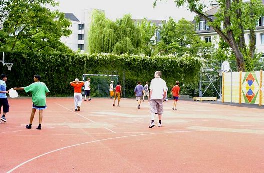 Campo
                          combinado en rojo en la escuela de
                          Schanzengraben en Zurich, con ftbol y
                          balonmano a lo largo y baloncesto de manera
                          transversal