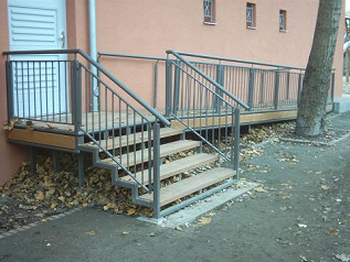 Eine Rollstuhlrampe (hier an einem
                                Kulturhaus in Berlin-Kreuzberg) darf nie
                                zu steil sein und muss immer auch ein
                                Gel�nder bzw. einen "Handlauf"
                                aufweisen, so sich die
                                RollstuhlfahrerInnen daran festhalten
                                k�nnen. Die L�sung ist ideal mit Rampe
                                und Treppenstufen, so dass man immer die
                                Wahl hat. Die Rampe dient dann auch den
                                Kinderwagen, und es spielen dann auch
                                Kinder auf der Rampe mit ihren
                                Fahrger�ten etc.