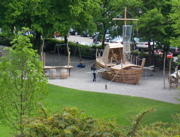 Barco volante en el parque infantil
                            "Kollerwiese" ("Prado de
                            Koller") 01 en el distrito de Wiedikon
                            en Zurich, Suiza [7], y la vista de atr�s
                            con el tobog�n