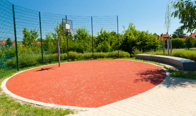 Baloncesto en la calle 01 en un pavimento
                          rojo de tart�n con un banco grande al fondo,
                          en Lausa, regi�n de Dresden, Alemania